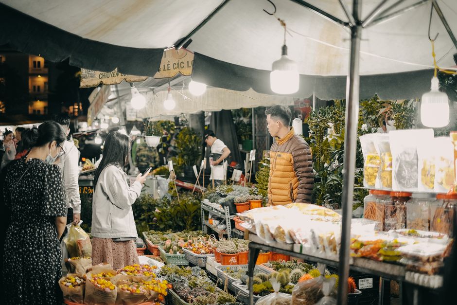 At the Maltby Street Market flower stalls, a floral arrangement featuring a variety of fresh flowers such as roses, chrysanthemums, and daisies in soft pastel and vibrant colours is displayed on a tab